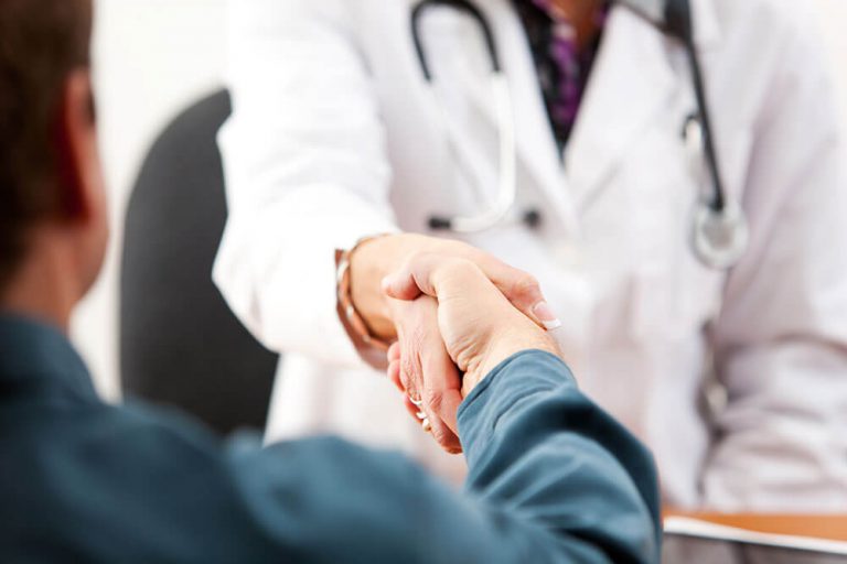 close up of doctor shaking hands with their patient.