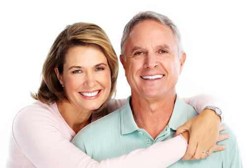 A woman with her arms over a man's shoulders while they're smiling