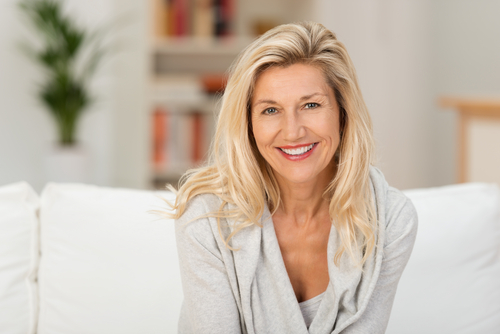 An older woman sitting on the couch and smiling